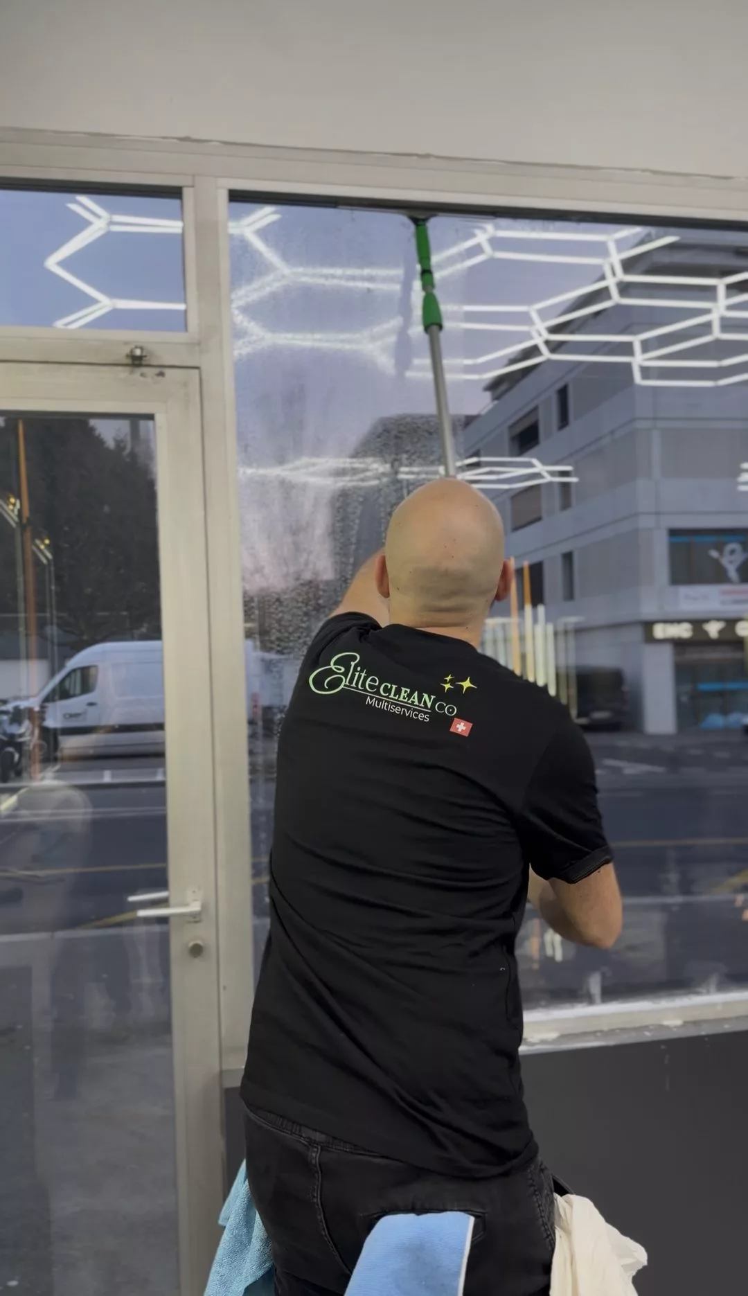 Nettoyage de vitrine d’un commerce à Lausanne par Raissi Nettoyage, perche et raclette professionnelle