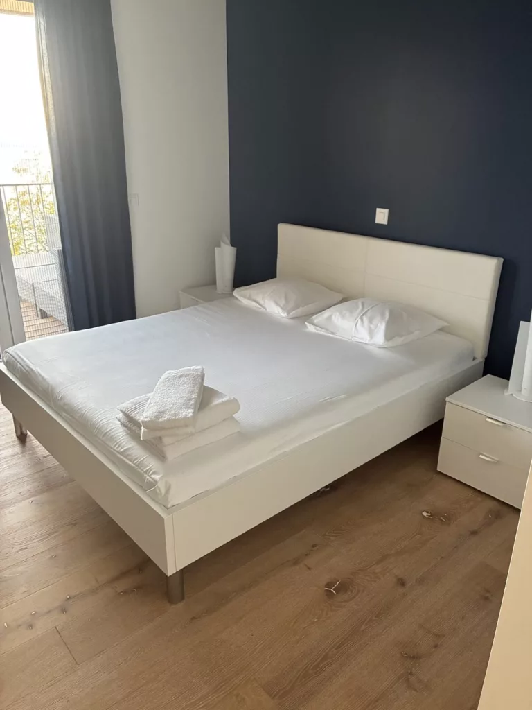 Nettoyage à Puidoux : chambre d'un appartement Airbnb préparée par Raissi Nettoyage, lit fait, serviettes pliées, balcon