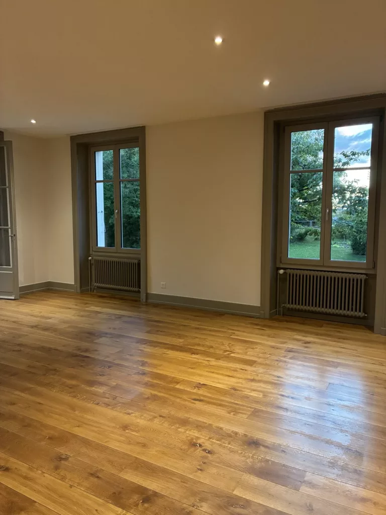 Nettoyage à Montricher : séjour vide avec parquet et pierre apparente préparé pour un état des lieux de sortie